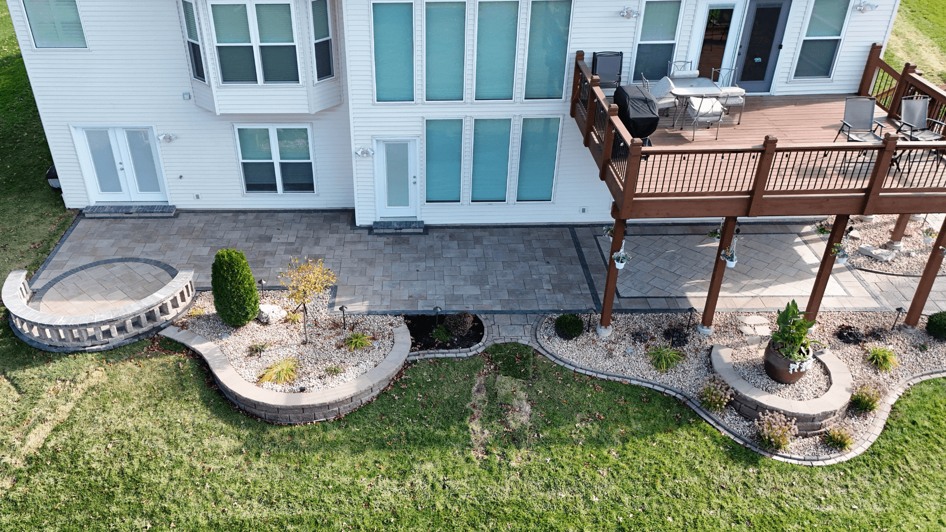 Stone Retaining Wall Along Driveway Stone retaining wall with capstones along residential driveway by NxGen Outdoors