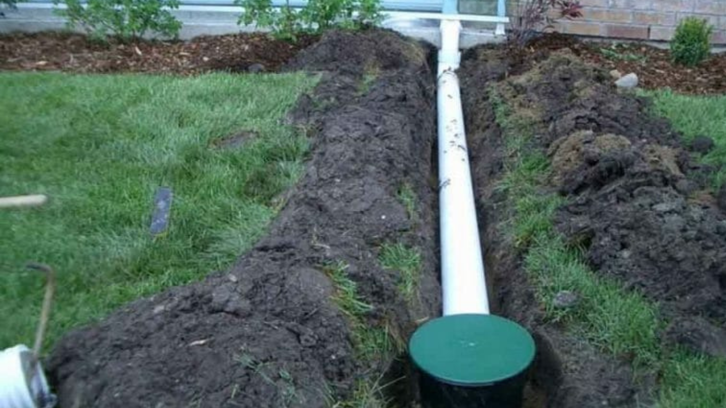 Yard drainage system installation with PVC pipe trench and pop-up emitter by NxGen Outdoors
