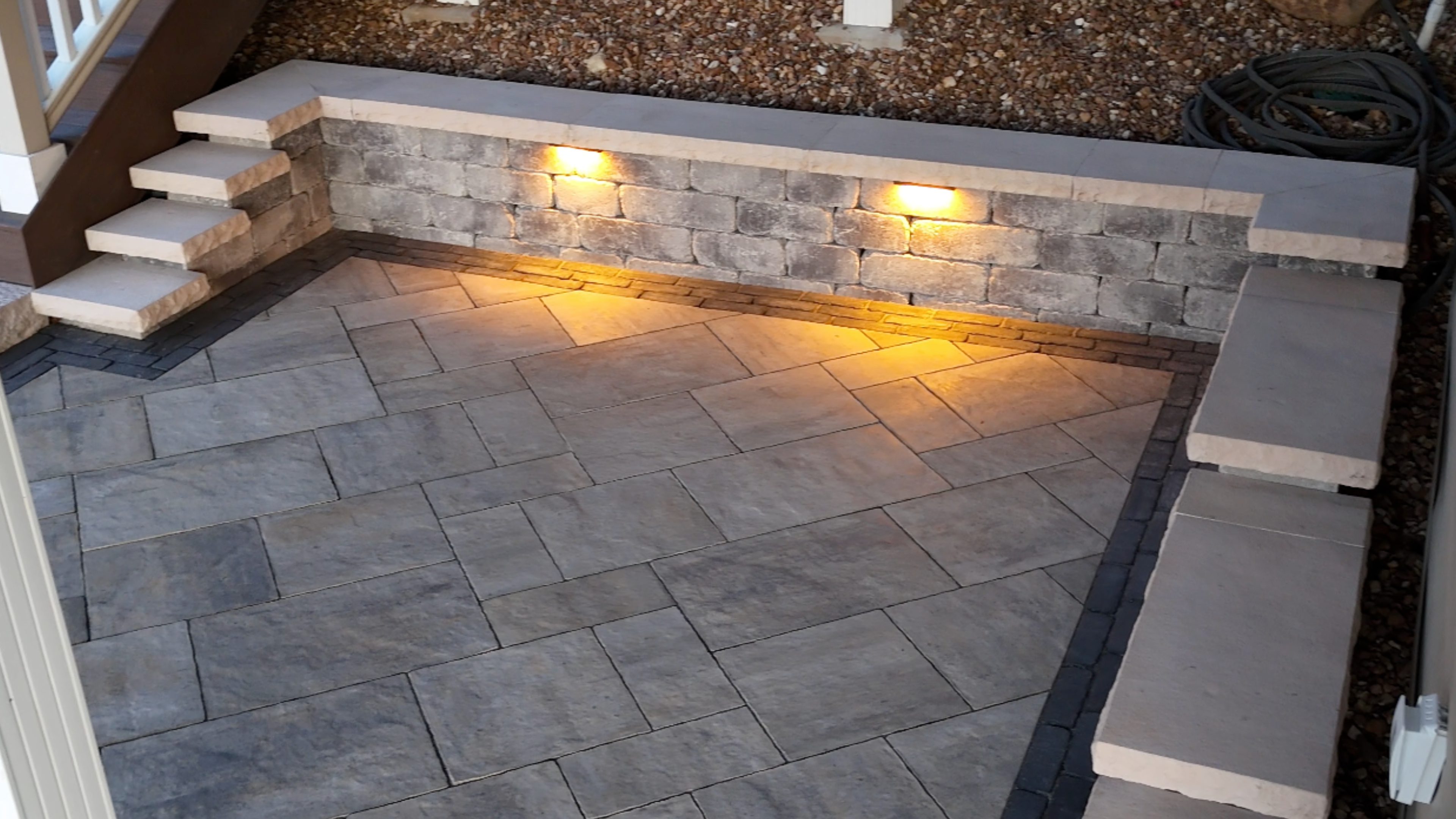 Stone retaining wall with LED accent lighting and paver patio